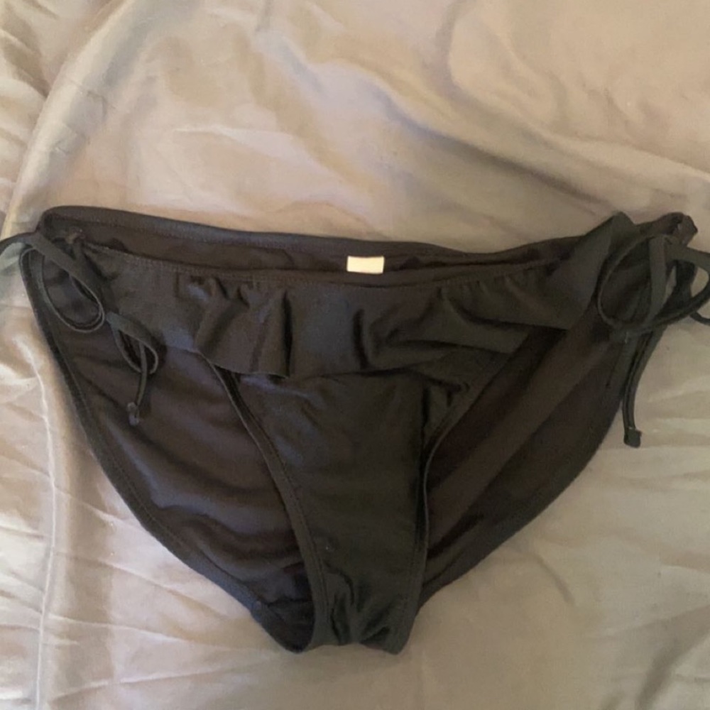 Black swimsuit bottoms with fringe on the front.